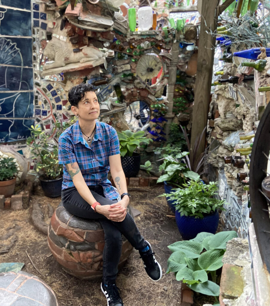 Tracy Levesque sitting outside in Philly Magic Gardens